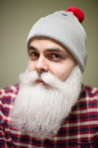 Mies tekoparrassa ja tupsupipo päässä hymyilee kameralle. Hän on Brother Christmas, salanimen takaa toimiva hyväntekijä.